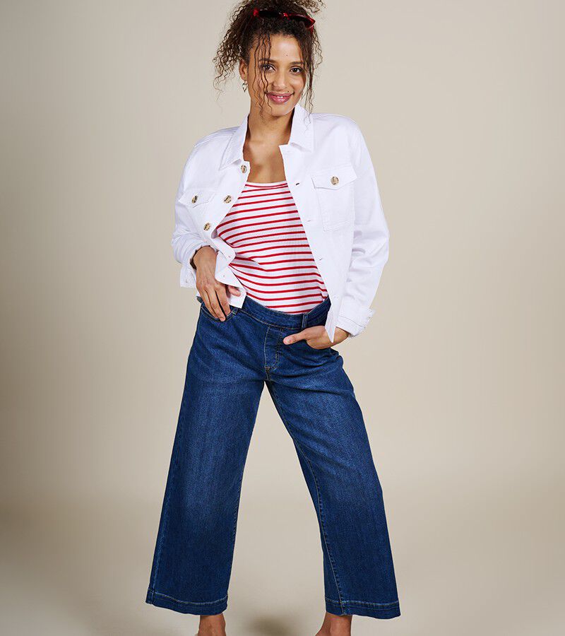 image of a woman wearing red stripped tank top, white denim jacket and dark wash wide leg jeans